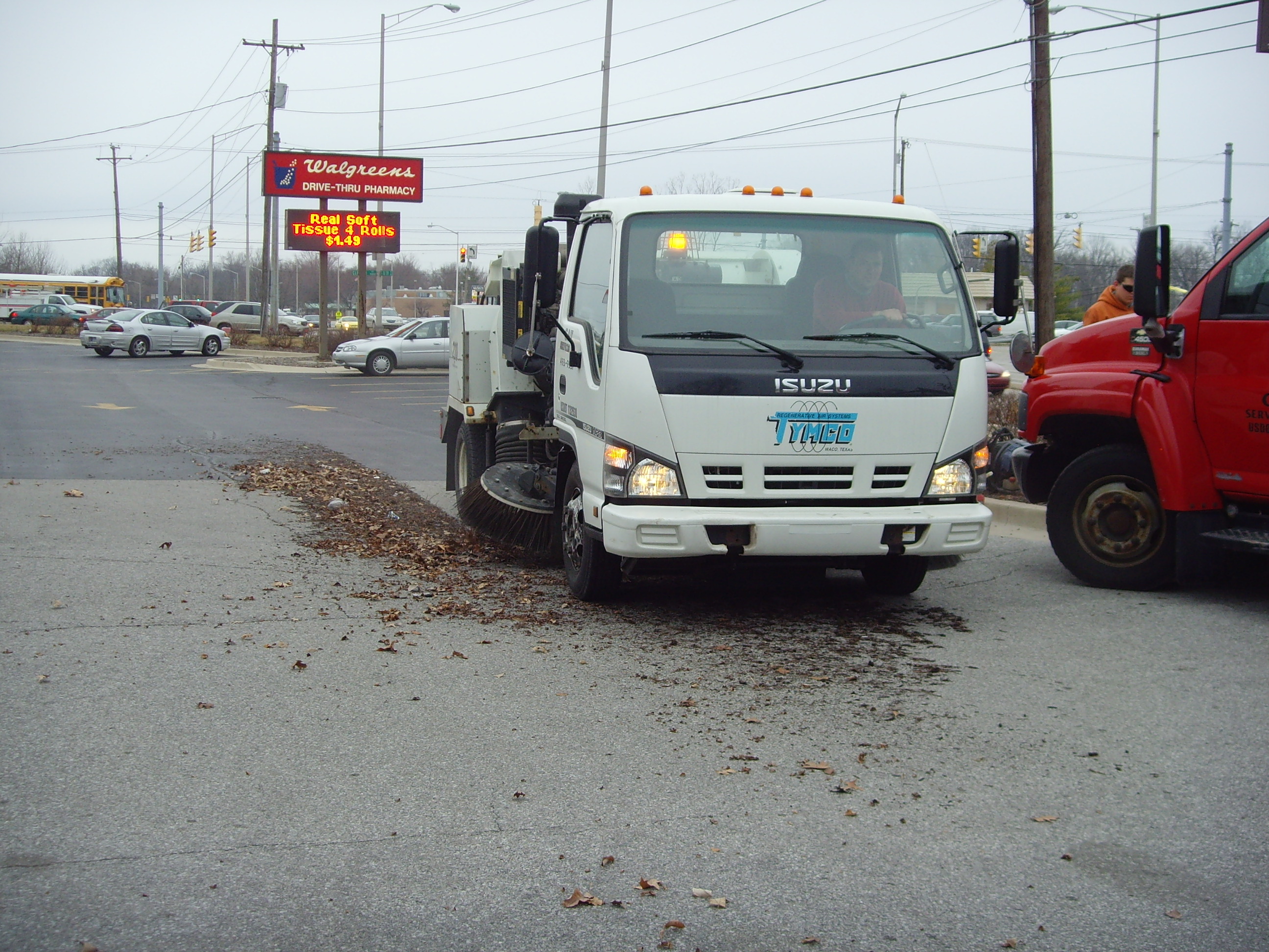 Sweeper truck clearing leaves from parking lot
