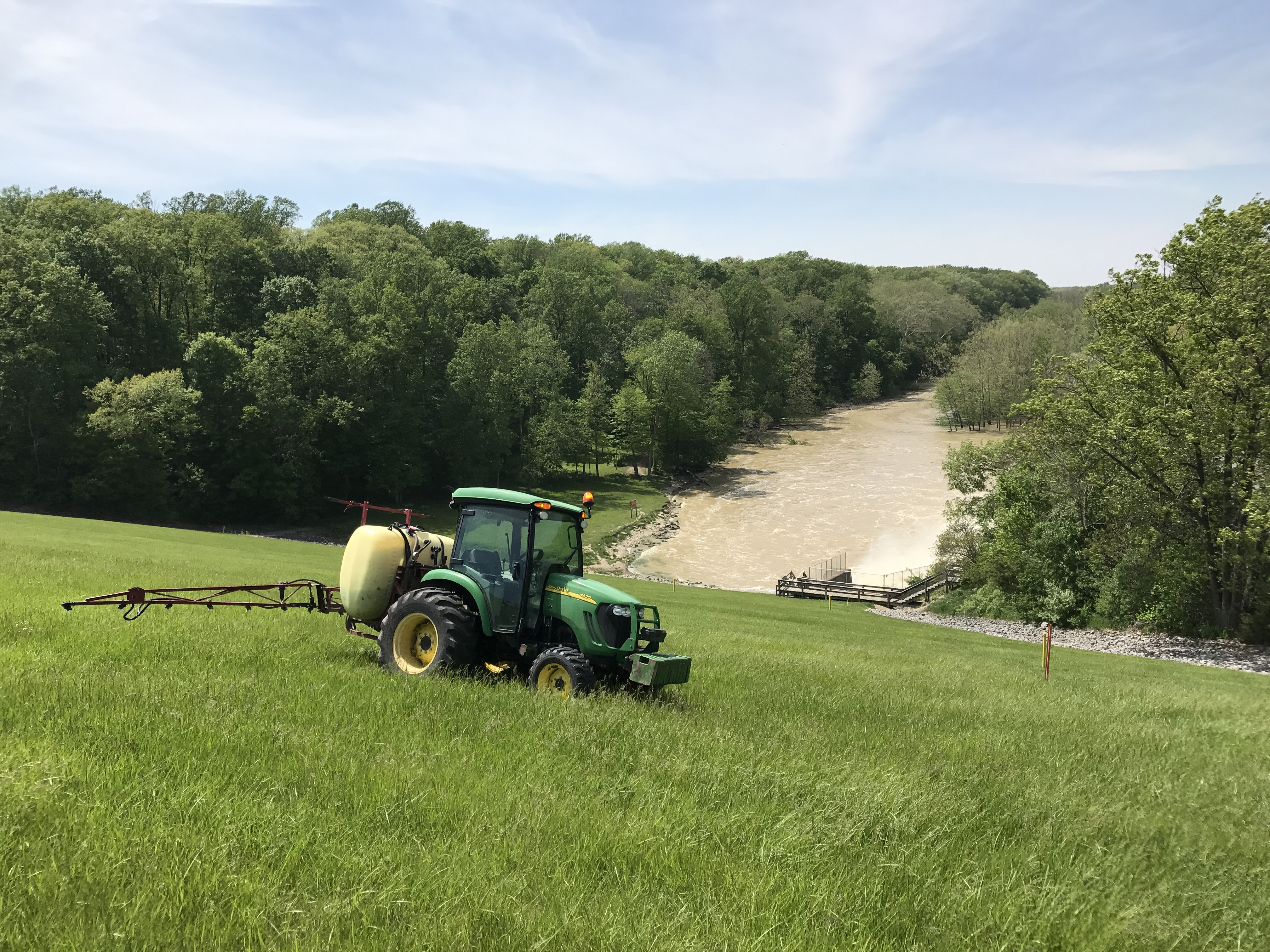 Tractor spraying weed control on hillside
